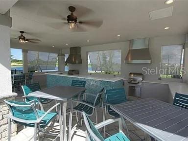 16124 Azure Key St, Winter Garden, FL 34787 - kitchen with range hood, a ceiling fan, wall chimney exhaust hood, and recessed lighting