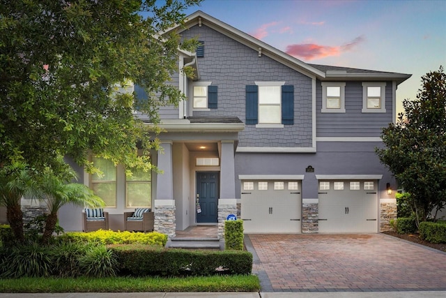 16124 Azure Key St, Winter Garden, FL 34787 - craftsman-style house featuring a garage, stone siding, decorative driveway, and stucco siding