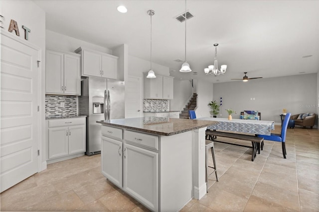 16124 Azure Key St, Winter Garden, FL 34787 - kitchen with stainless steel fridge, decorative backsplash, a kitchen island, ceiling fan, and white cabinets