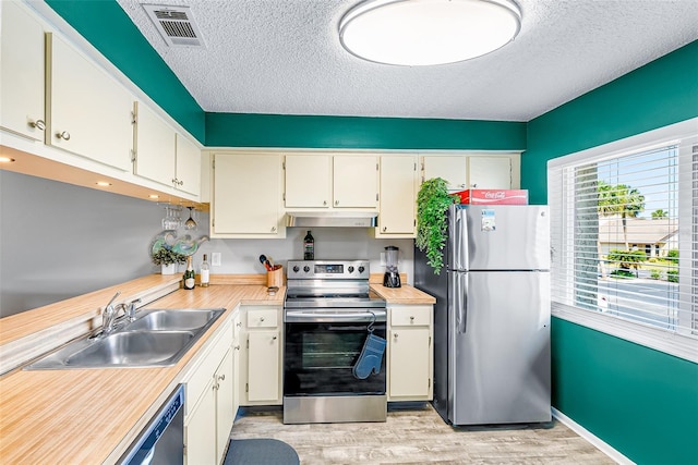 2175 Golf Isle Dr Unit 1022, Melbourne, FL 32935 - kitchen featuring visible vents, a textured ceiling, under cabinet range hood, a sink, and stainless steel appliances