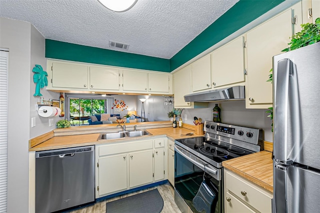 2175 Golf Isle Dr Unit 1022, Melbourne, FL 32935 - kitchen featuring visible vents, a sink, light countertops, under cabinet range hood, and stainless steel appliances