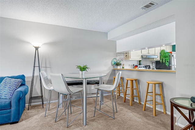2175 Golf Isle Dr Unit 1022, Melbourne, FL 32935 - dining area with carpet floors, a textured ceiling, baseboards, and visible vents