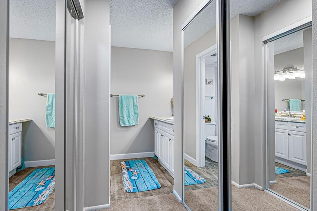 2175 Golf Isle Dr Unit 1022, Melbourne, FL 32935 - full bath featuring vanity, a textured ceiling, wood finished floors, and toilet