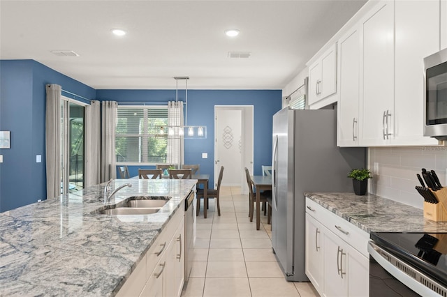 kitchen featuring a sink, decorative backsplash, white cabinets, and stainless steel appliances
