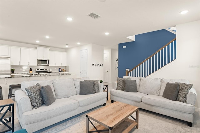living area with visible vents, recessed lighting, and stairway