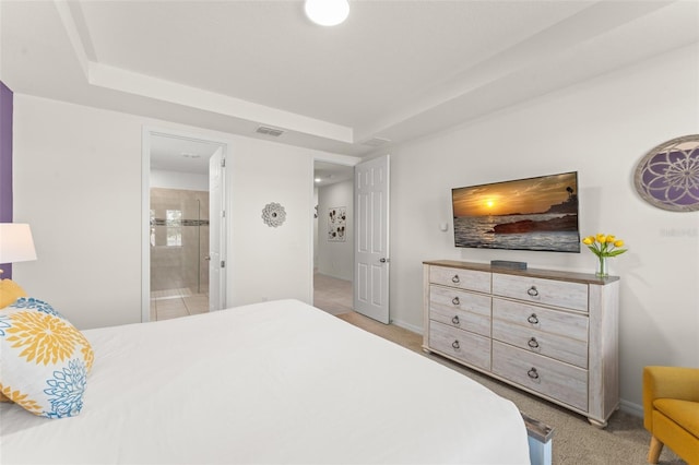bedroom featuring visible vents, connected bathroom, baseboards, and light carpet