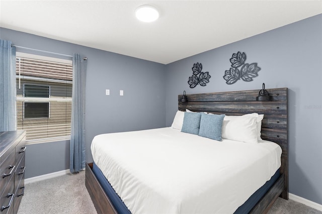 bedroom with baseboards and light colored carpet
