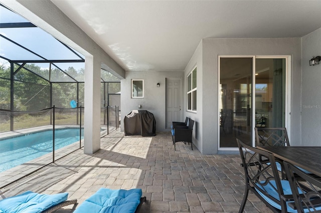 view of patio with area for grilling, a lanai, and an outdoor pool