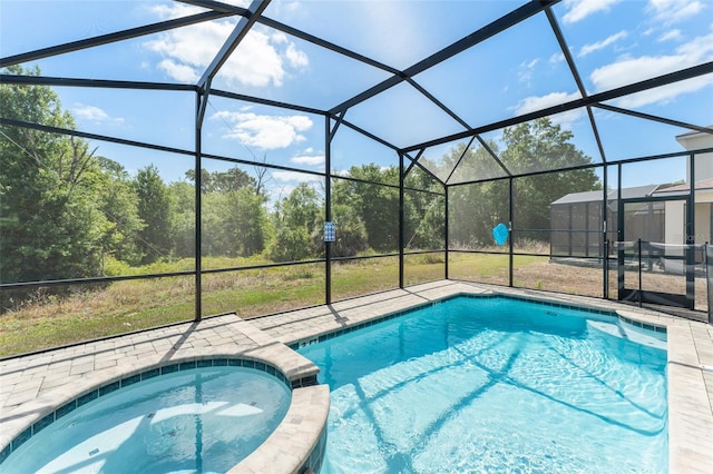 view of pool featuring a lanai, a pool with connected hot tub, and a patio