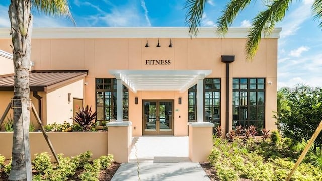 entrance to property with french doors and stucco siding