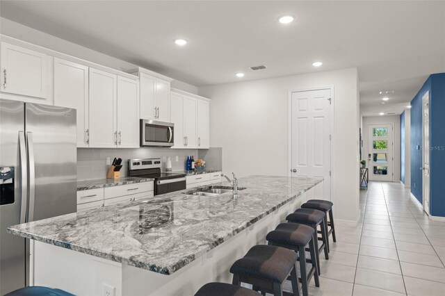 2009 Tropical Palms Cir, Kissimmee, FL 34747 - kitchen featuring appliances with stainless steel finishes, a sink, light tile patterned flooring, recessed lighting, and a kitchen breakfast bar