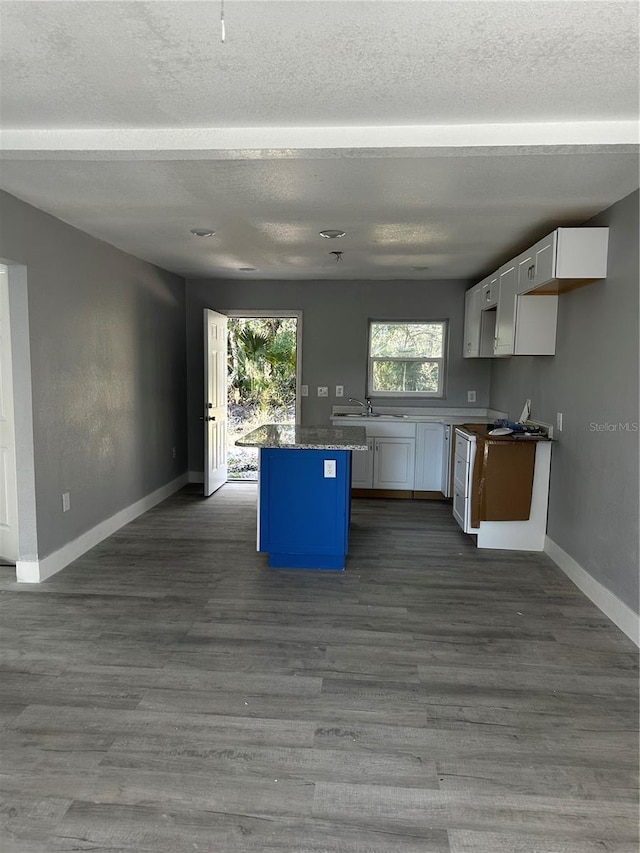 210 Church St, Davenport, FL 33896 - kitchen with baseboards, dark wood-style flooring, white cabinetry, and a kitchen island