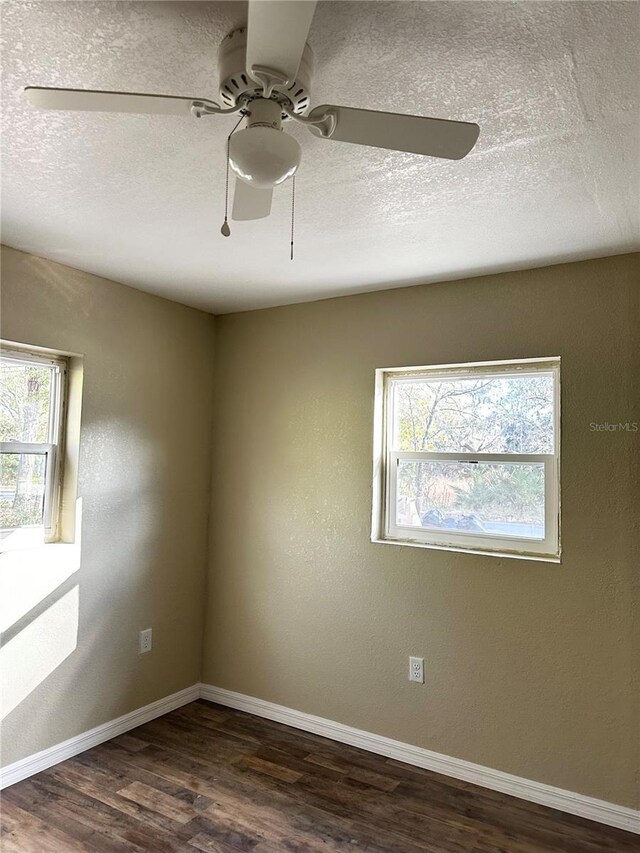 210 Church St, Davenport, FL 33896 - spare room with dark wood finished floors, a wealth of natural light, ceiling fan, and baseboards