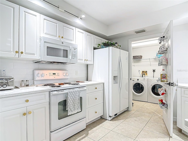 5300 S Atlantic Ave Unit 9-302, New Smyrna Beach, FL 32169 - kitchen with washing machine and clothes dryer, white appliances, white cabinets, and visible vents