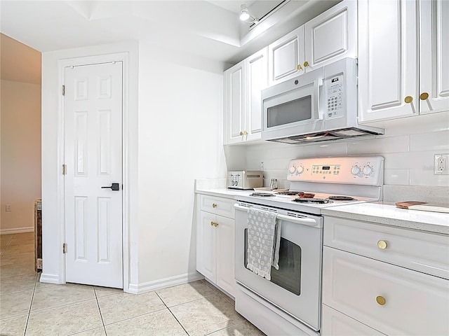 5300 S Atlantic Ave Unit 9-302, New Smyrna Beach, FL 32169 - kitchen featuring baseboards, white cabinetry, light tile patterned flooring, and white appliances