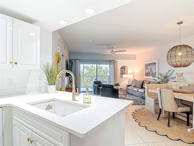 5300 S Atlantic Ave Unit 9-302, New Smyrna Beach, FL 32169 - kitchen with a sink, light tile patterned flooring, decorative light fixtures, white cabinetry, and light stone countertops