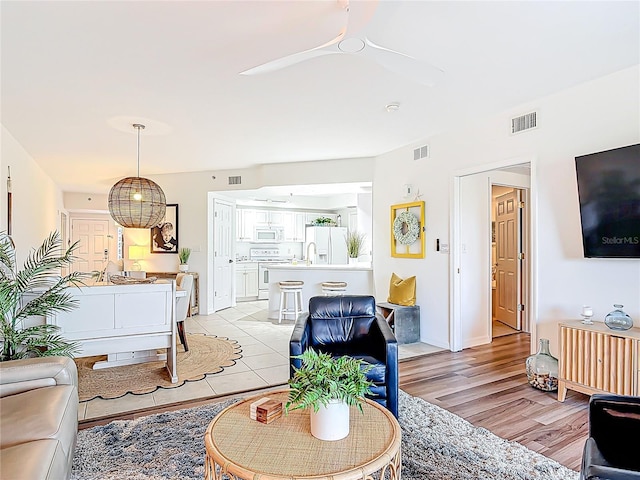 5300 S Atlantic Ave Unit 9-302, New Smyrna Beach, FL 32169 - living room with baseboards, light wood-style flooring, visible vents, and ceiling fan