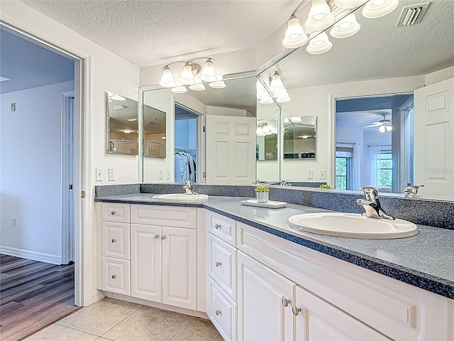 5300 S Atlantic Ave Unit 9-302, New Smyrna Beach, FL 32169 - full bath with a sink, a textured ceiling, double vanity, visible vents, and ceiling fan