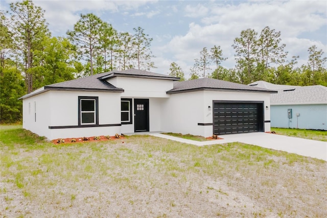 view of front of property featuring a front lawn, a garage, driveway, roof with shingles, and stucco siding