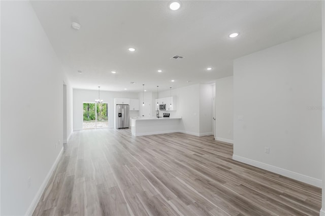 unfurnished living room with recessed lighting, visible vents, baseboards, and light wood-type flooring
