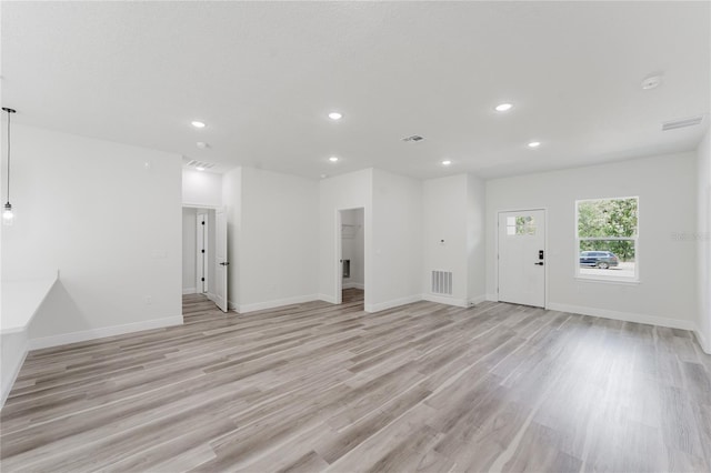 unfurnished living room with visible vents, recessed lighting, baseboards, and light wood-style floors