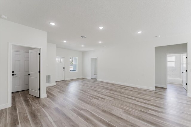 unfurnished living room with visible vents, light wood-type flooring, recessed lighting, and baseboards