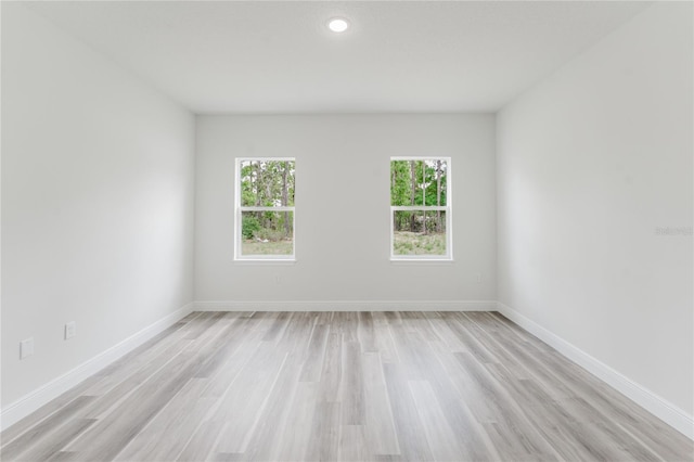 unfurnished room with baseboards, recessed lighting, and light wood-style flooring