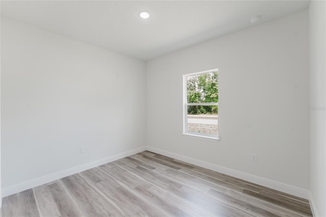 spare room featuring baseboards, recessed lighting, and light wood-style flooring