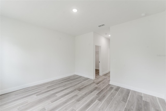 spare room featuring recessed lighting, light wood finished floors, visible vents, and baseboards