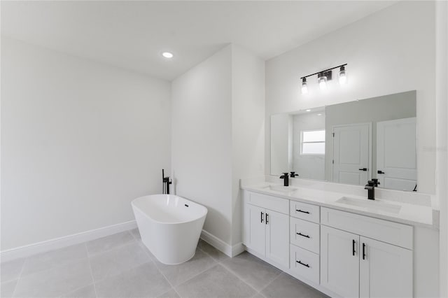 full bathroom with double vanity, a sink, a soaking tub, and baseboards
