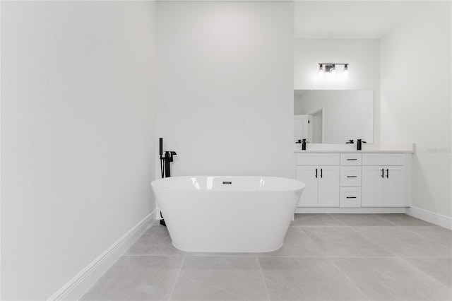 full bathroom with tile patterned floors, a freestanding bath, vanity, and baseboards