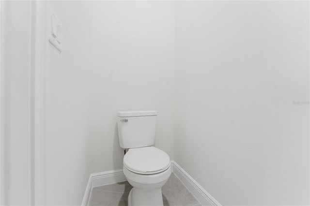 bathroom with toilet, tile patterned flooring, and baseboards