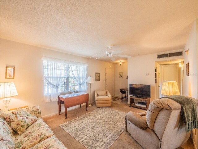carpeted living room featuring baseboards, a ceiling fan, and visible vents