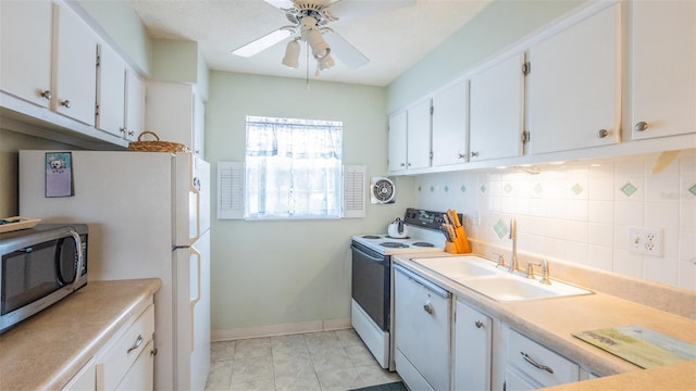 kitchen with white cabinets, white appliances, a sink, and tasteful backsplash