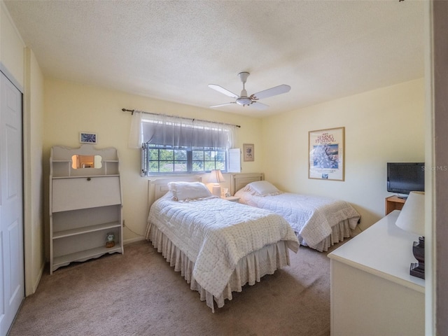 bedroom featuring light carpet, a ceiling fan, and a textured ceiling