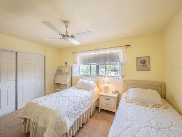 bedroom featuring a closet, a ceiling fan, and light colored carpet