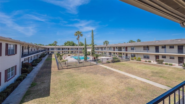 exterior space with fence, a yard, and a residential view