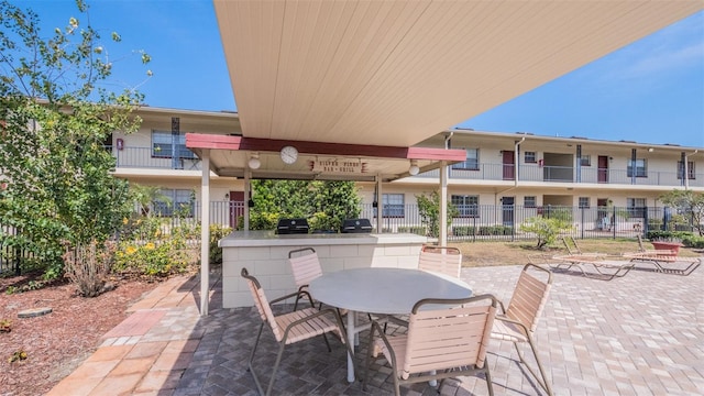 view of patio with fence, an outdoor kitchen, outdoor dining space, and area for grilling