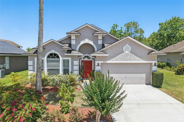 9915 Kona Isle Ct, Orlando, FL 32817 - view of front facade featuring stucco siding, a garage, concrete driveway, central air condition unit, and a front lawn