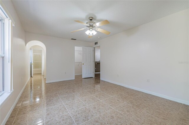 50989 Hwy 27 Unit 371, Davenport, FL 33897 - empty room featuring arched walkways, ceiling fan, and baseboards