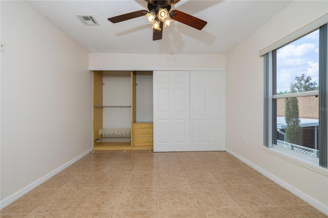 50989 Hwy 27 Unit 371, Davenport, FL 33897 - unfurnished bedroom featuring a closet, light tile patterned flooring, baseboards, a ceiling fan, and a textured ceiling