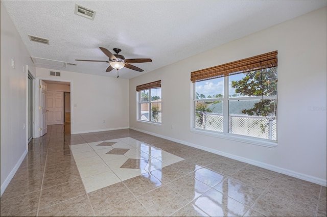 50989 Hwy 27 Unit 371, Davenport, FL 33897 - empty room featuring light tile patterned floors, a ceiling fan, a textured ceiling, baseboards, and attic access