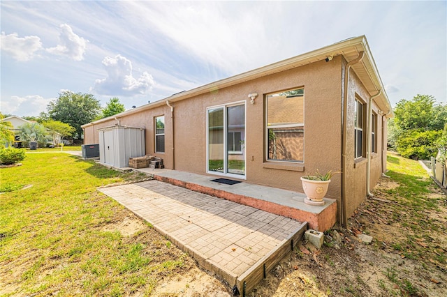 50989 Hwy 27 Unit 371, Davenport, FL 33897 - back of house with central AC unit, a patio area, a yard, and stucco siding