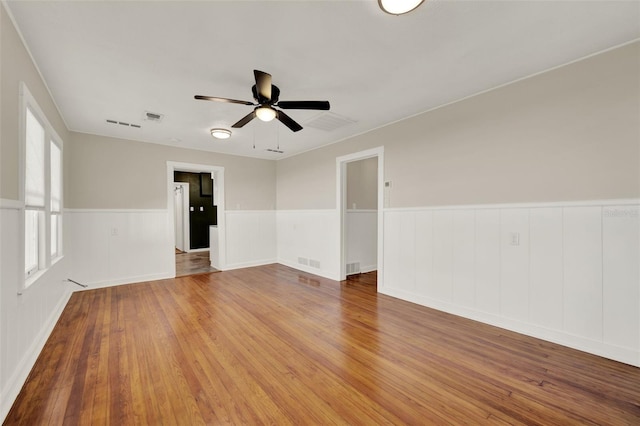 508 10th St, Saint Cloud, FL 34769 - unfurnished room with a wainscoted wall, a ceiling fan, and hardwood / wood-style floors