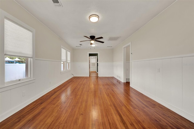 508 10th St, Saint Cloud, FL 34769 - empty room with a ceiling fan, wood finished floors, wainscoting, and a decorative wall