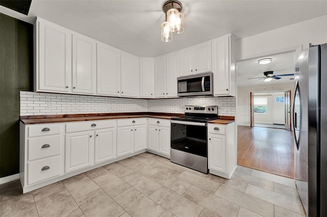 508 10th St, Saint Cloud, FL 34769 - kitchen with stainless steel appliances, butcher block counters, tasteful backsplash, and white cabinets