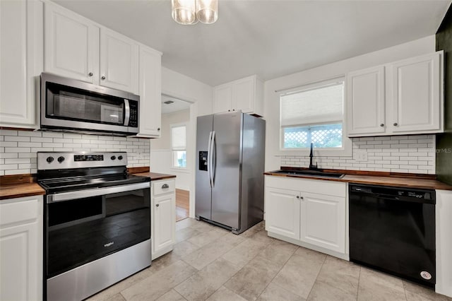 508 10th St, Saint Cloud, FL 34769 - kitchen with stainless steel appliances, wooden counters, decorative backsplash, and white cabinets