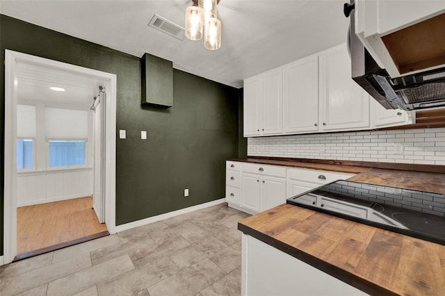 508 10th St, Saint Cloud, FL 34769 - kitchen featuring wood counters, stainless steel microwave, ceiling fan, decorative backsplash, and white cabinetry