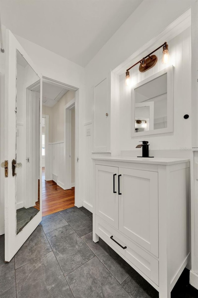 508 10th St, Saint Cloud, FL 34769 - bathroom featuring vanity, a wainscoted wall, and a decorative wall