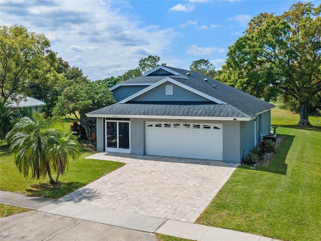 2710 Alabaster Ave, Orlando, FL 32833 - view of front of home with decorative driveway, a garage, a front yard, stucco siding, and roof with shingles